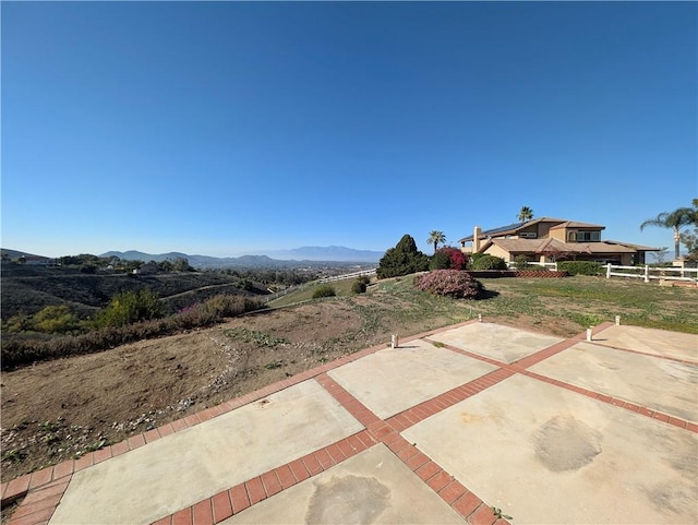 view of yard featuring a mountain view, fence, and a patio area