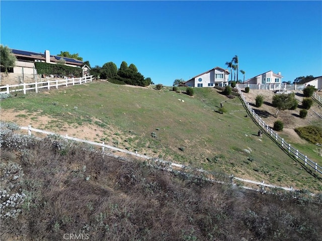 view of yard with fence and a rural view