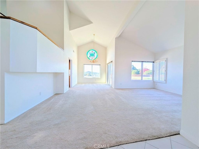 carpeted empty room with high vaulted ceiling
