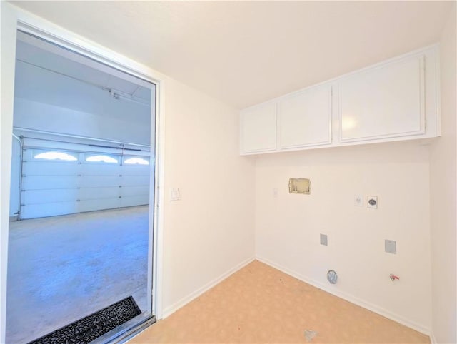 clothes washing area with gas dryer hookup, baseboards, light floors, hookup for an electric dryer, and cabinet space