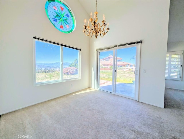 carpeted empty room featuring an inviting chandelier and a high ceiling