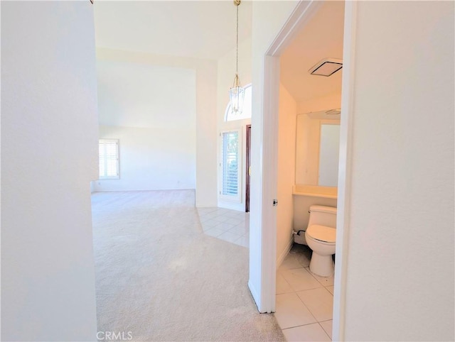 hallway with light tile patterned flooring, visible vents, and light carpet