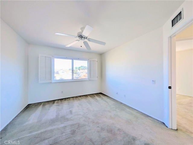 empty room with carpet flooring, visible vents, and a ceiling fan