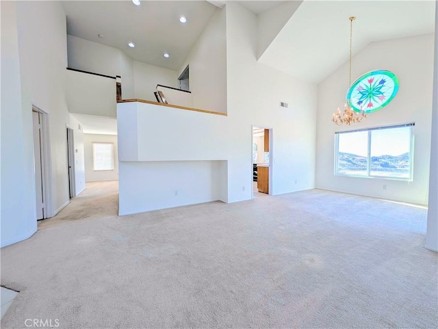 unfurnished living room with light colored carpet, a wealth of natural light, and a chandelier