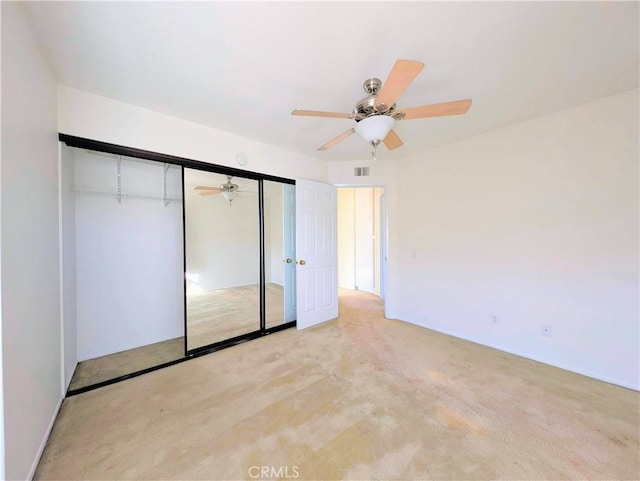 unfurnished bedroom with carpet, a closet, ceiling fan, and visible vents