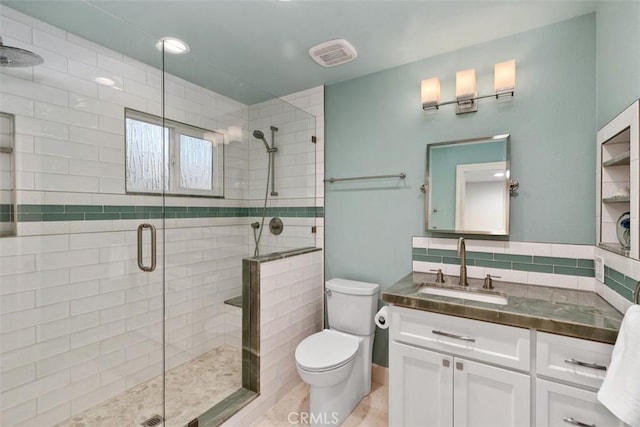 full bath with a shower stall, vanity, visible vents, and toilet