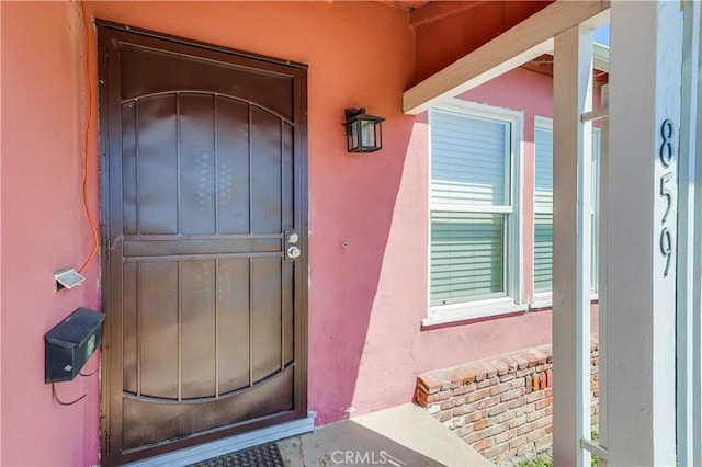 view of exterior entry featuring stucco siding