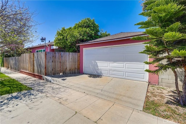 garage with fence and driveway