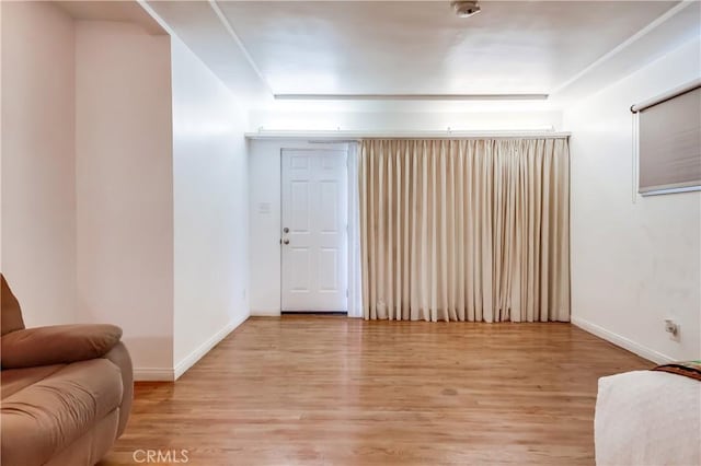 living area with baseboards and light wood finished floors
