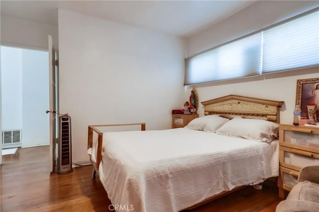 bedroom featuring visible vents and wood finished floors