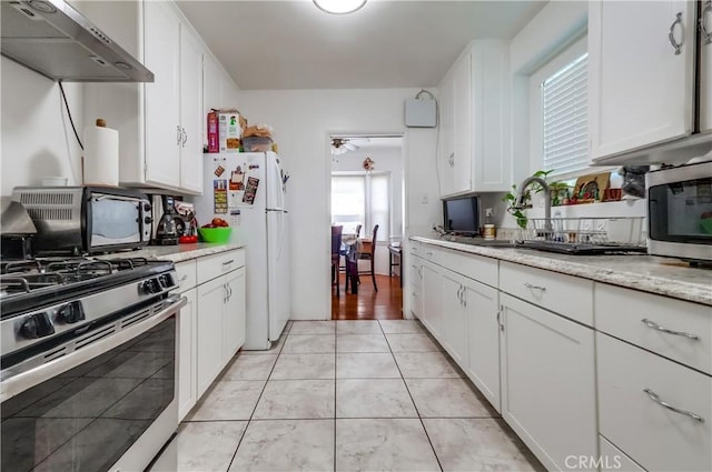 kitchen featuring stainless steel appliances, under cabinet range hood, and white cabinets