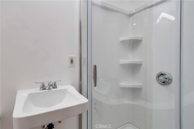 bathroom with a sink and a stall shower