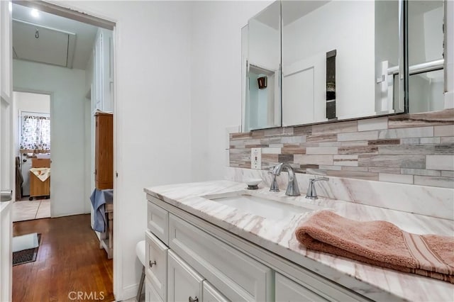 bathroom featuring backsplash, vanity, and wood finished floors
