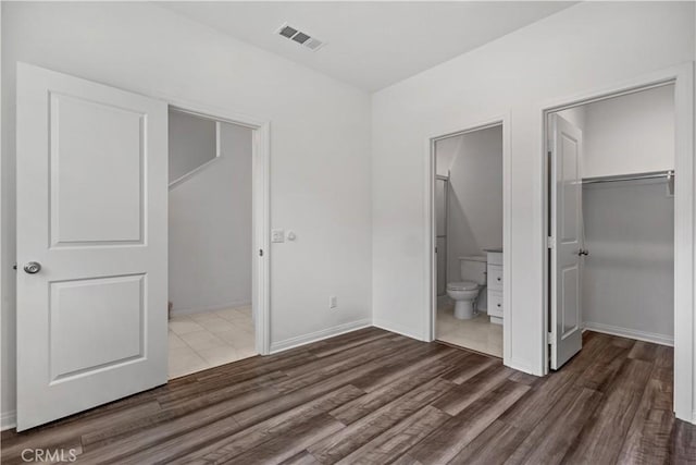 6991 Cottonwood Ln, Buena Park, CA 90621 - unfurnished bedroom featuring a walk in closet, wood finished floors, a closet, and connected bathroom
