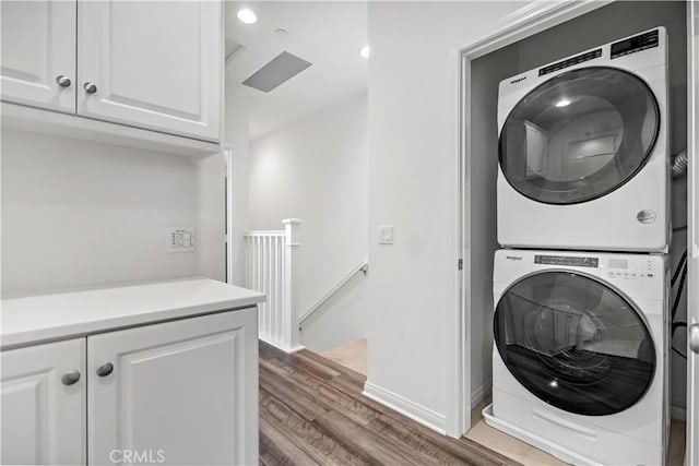 6991 Cottonwood Ln, Buena Park, CA 90621 - laundry room with stacked washer and clothes dryer, wood finished floors, and recessed lighting