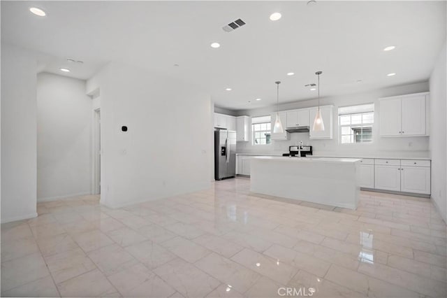 6991 Cottonwood Ln, Buena Park, CA 90621 - kitchen with stainless steel fridge, white cabinets, recessed lighting, under cabinet range hood, and a center island
