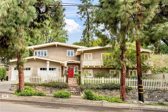 view of front of property with concrete driveway, a fenced front yard, and a garage