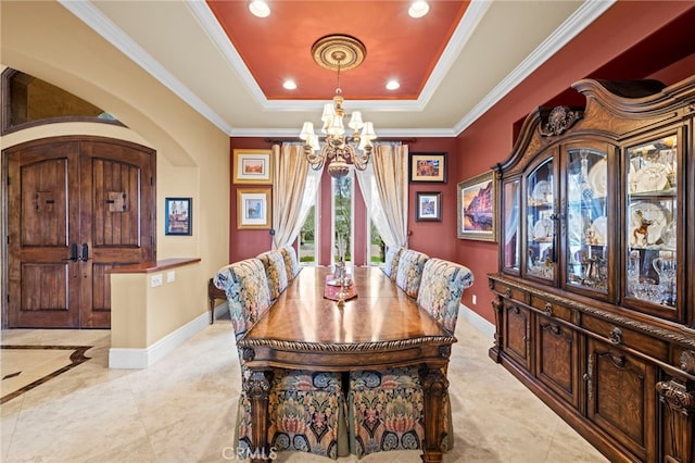 dining space with an inviting chandelier, ornamental molding, a tray ceiling, and baseboards