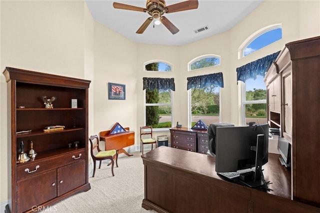 carpeted office space featuring visible vents and ceiling fan