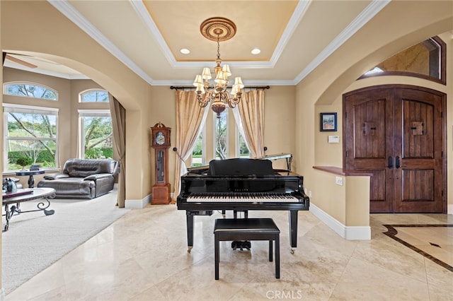 sitting room featuring ornamental molding, baseboards, arched walkways, and a notable chandelier
