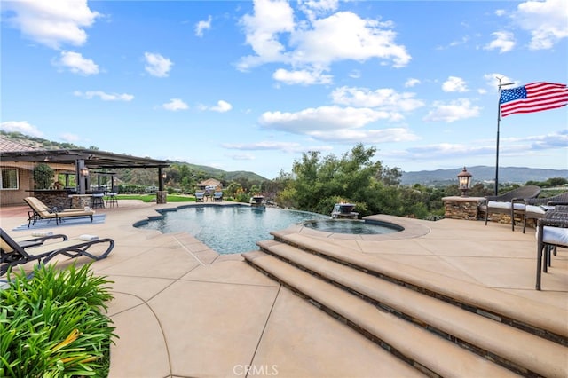 outdoor pool featuring a patio, a mountain view, and an in ground hot tub