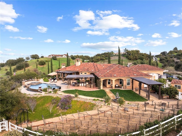 back of property with a patio area, a fenced backyard, a chimney, and a tile roof