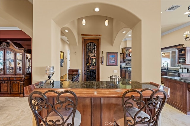 bar with visible vents, arched walkways, recessed lighting, and wet bar