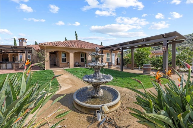 back of house featuring a patio, a yard, stucco siding, and a tile roof