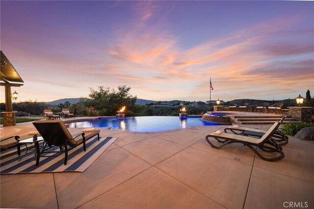 view of pool featuring a patio area and a pool with connected hot tub