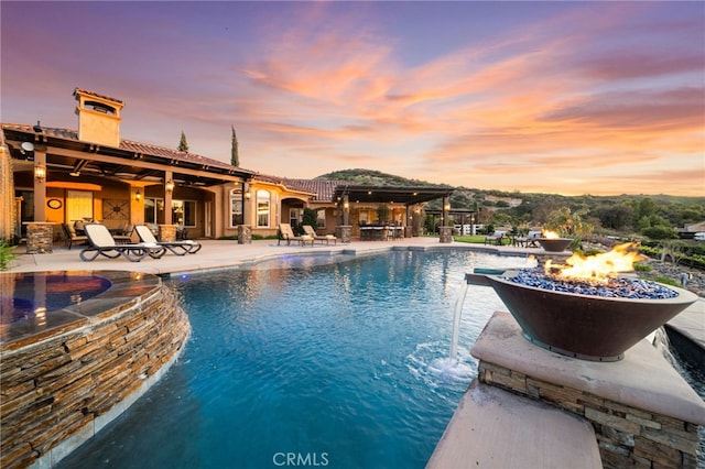 view of swimming pool featuring a fire pit, a patio area, and a pool with connected hot tub