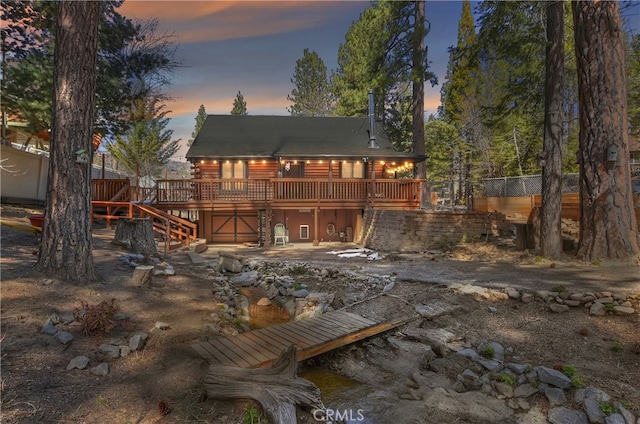 2424 Spruce Dr, Running Springs, CA 92382 - back of house at dusk featuring a wooden deck, log exterior, and stairs