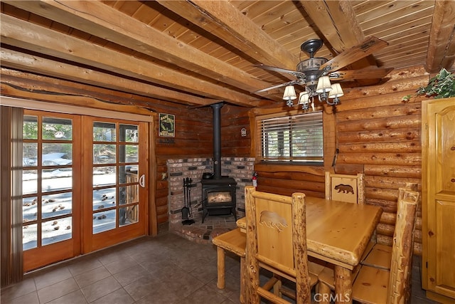 2424 Spruce Dr, Running Springs, CA 92382 - dining space with a wood stove, wood ceiling with exposed beams, dark tile patterned floors, ceiling fan, and log walls