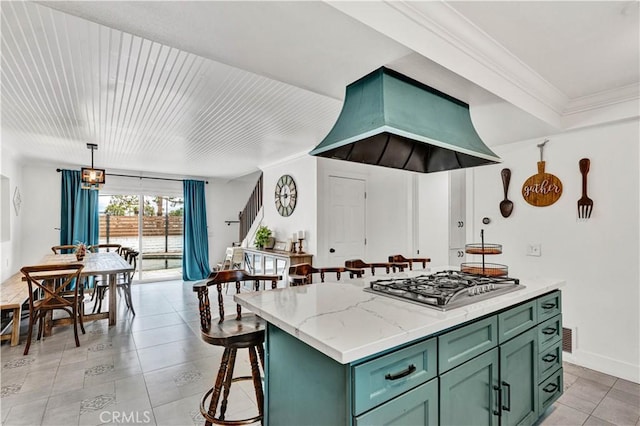 kitchen with ornamental molding, light stone counters, extractor fan, green cabinetry, and stainless steel gas stovetop