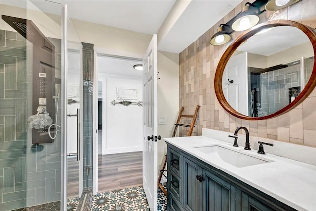 full bathroom featuring tile walls, a shower stall, and vanity