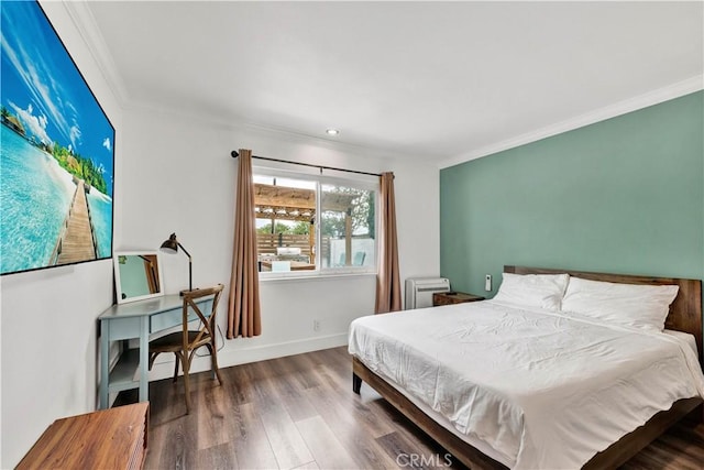 bedroom featuring crown molding, baseboards, and wood finished floors