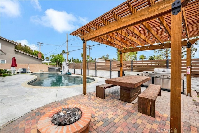 view of swimming pool featuring a fenced in pool, an outdoor kitchen, a pergola, a water slide, and a fenced backyard