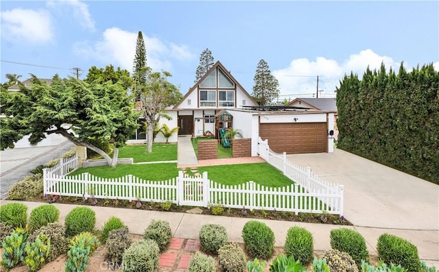 tudor house featuring a fenced front yard, a front yard, driveway, and a garage