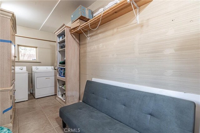 washroom with light tile patterned flooring, washing machine and dryer, and laundry area