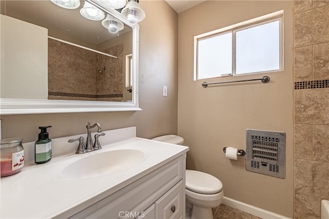 bathroom with toilet, vanity, tiled shower, heating unit, and tile patterned flooring