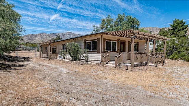 back of house featuring a pergola and a mountain view