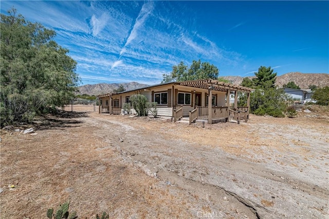 back of house featuring a mountain view and a pergola