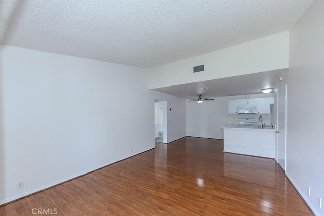23222 Orange Ave Unit 4, Lake Forest, CA 92630 - unfurnished living room with a textured ceiling, visible vents, ceiling fan, a sink, and wood finished floors