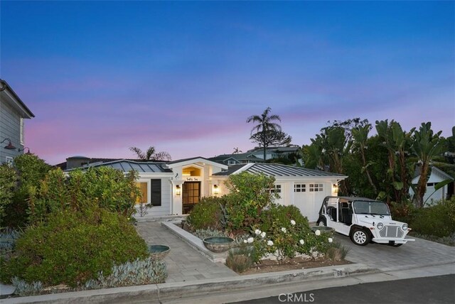 66 S La Senda Dr, Laguna Beach, CA 92651 - view of front facade with a garage, metal roof, driveway, and a standing seam roof
