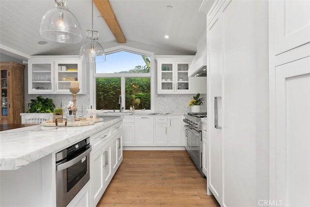 66 S La Senda Dr, Laguna Beach, CA 92651 - kitchen featuring light wood-style floors, wall chimney exhaust hood, tasteful backsplash, a sink, and appliances with stainless steel finishes