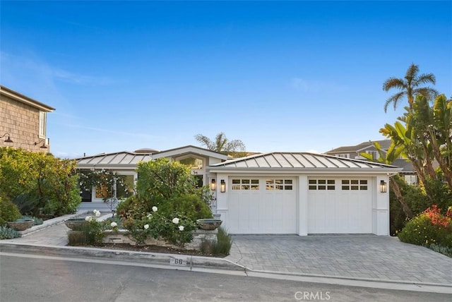 66 S La Senda Dr, Laguna Beach, CA 92651 - view of front of house featuring a standing seam roof, metal roof, a garage, decorative driveway, and stucco siding