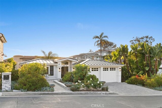 66 S La Senda Dr, Laguna Beach, CA 92651 - view of front of home with a standing seam roof, driveway, and metal roof