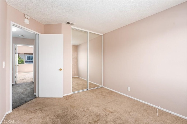 1076 N Ironwood Ave, Rialto, CA 92376 - unfurnished bedroom featuring visible vents, a closet, carpet, and a textured ceiling
