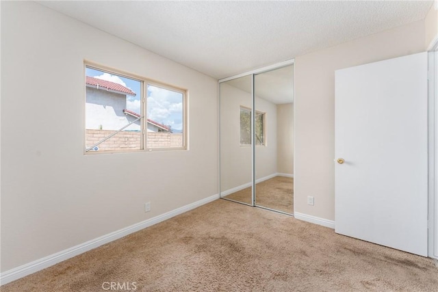 1076 N Ironwood Ave, Rialto, CA 92376 - unfurnished bedroom with baseboards, a closet, carpet, and a textured ceiling