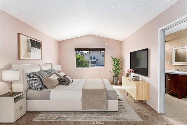 1076 N Ironwood Ave, Rialto, CA 92376 - bedroom featuring lofted ceiling, baseboards, a sink, ensuite bath, and light carpet