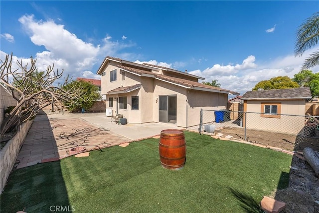 1076 N Ironwood Ave, Rialto, CA 92376 - rear view of house with a fenced backyard, a lawn, stucco siding, and a patio area